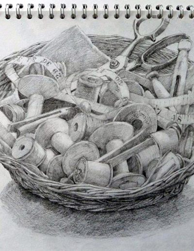 A pencil sketchbook drawing of a haberdashery basket, containing scissors, measuring tape, wooden split pegs and full of bobbins.